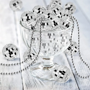 Macro shot of silver mirror disco balls in a glass bowl with beaded chain