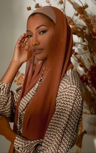 Detail of burnt orange chiffon hijab scarf with soft breathable texture on model