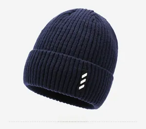 Side view of dark blue ribbed knit beanie with thick fold-over cuff and athletic fabric patch