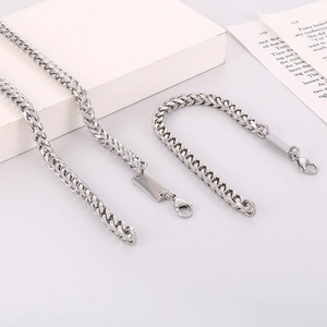 Macro shot of silver titanium steel curb chain texture with secure lobster clasp