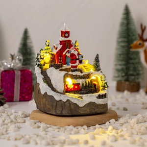 Close-up of luminous Christmas house with miniature train and warm LED lighting effect