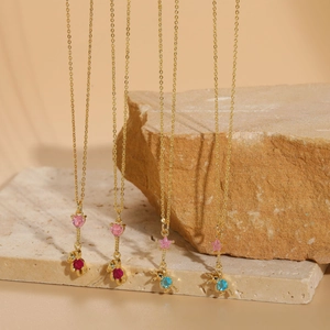 Detailed close-up of gold necklaces with bear, rabbit, heart and star zircon pendants