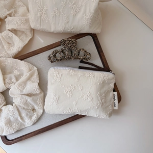 Detailed set of cream cotton bags with floral embroidery, scrunchie and hair clip