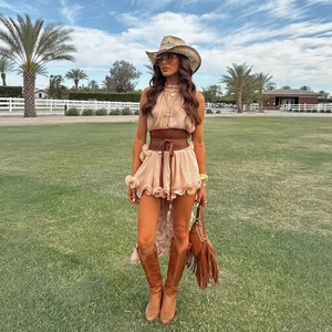 Bohemian apricot ruffle dress set with wide leather belt and western boots on sunny lawn