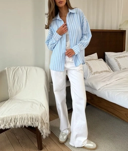 Chemise à rayures bleues claires et pantalon blanc portés dans une chambre à coucher