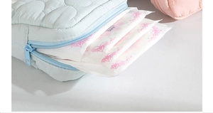 Detailed view of light blue quilted storage bag showing capacity for personal care items