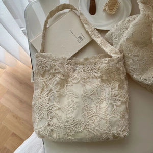 Close-up of floral lace embroidery texture and simple wish label on cotton tote bag