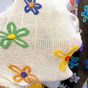Macro shot of colorful floral embroidery and intricate hollow knit texture on cotton socks