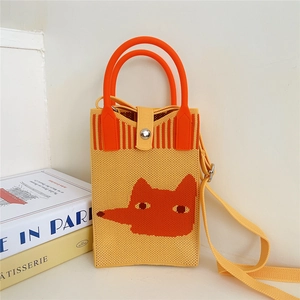 Detail of cute fox pattern on yellow knitted mini bag with bright metal buckle strap