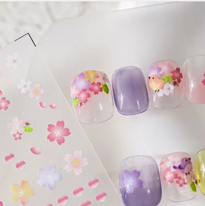 Close-up of matte floral nail stickers with cherry blossoms and colorful birds
