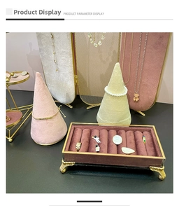 Detailed display of gold rings, pearl bracelets and necklaces on velvet jewelry stands