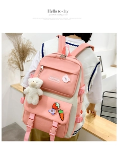 Pink and cream canvas backpack set shown on model with cute badges and plush bear