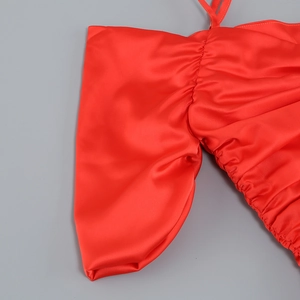Details des roten Satinkleides mit eleganter Raffung und glatter seidenartiger Textur