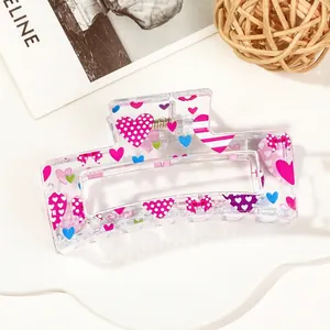 Close-up of semi-transparent hair claw clip with colorful heart and bow pattern