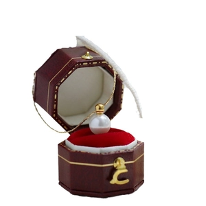 Single white pearl pendant on fine 18K gold chain displayed in a vintage red gift box