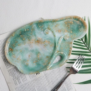 Detail view of a green marble resin jewelry tray with gold foil and glitter finish