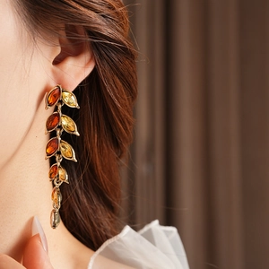 Gros plan de boucles d'oreilles vintage à pampilles épi de blé dorées et cristaux ambrés