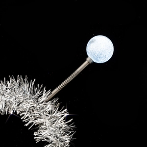 Close-up of silver glitter ball accessory on a flexible metal spring for alien headbands