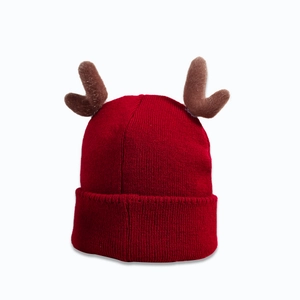 Close-up of red ribbed knit Christmas beanie featuring brown plush reindeer antlers detail