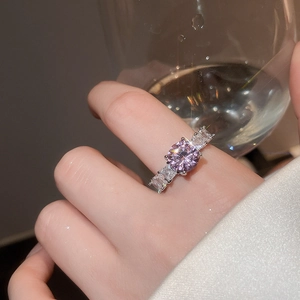 Detail of elegant silver ring featuring a round purple zircon and baguette side stones