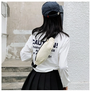 Off-white canvas crossbody bag styled on a model against a minimalist urban background