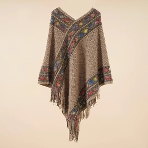 Detail showing the intricate fringe hem and colorful patterned trim of the brown poncho wrap