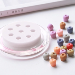 Close-up of 9-cavity silicone mold with colorful DIY apple-shaped resin crafts