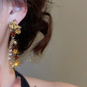 Detailed shot of French style floral tassel earrings with yellow and brown gemstones