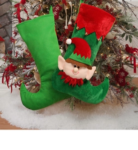 Detail view of green and red Christmas elf boot stockings with bells on a decorated tree
