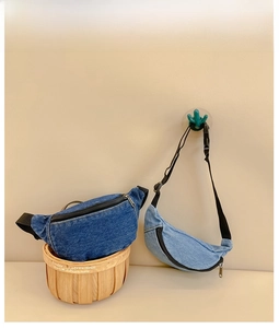 Detail of denim waist bags in dark and light blue with adjustable black straps