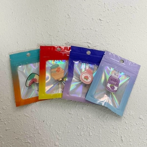 Holographic gradient resealable bags for jewelry with colorful enamel pins inside