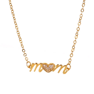 Detail of gold MOM necklace with heart-shaped pendant featuring sparkling zircon micro-inlay
