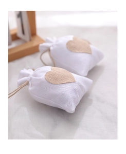 Close-up of small white linen drawstring gift bags with a stitched burlap heart patch