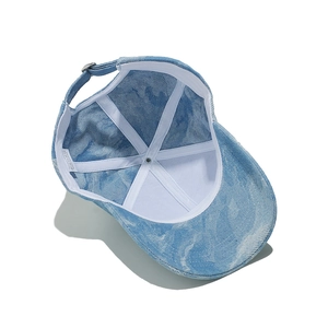 Detail of light blue washed denim cap interior showing white sweatband and metal buckle