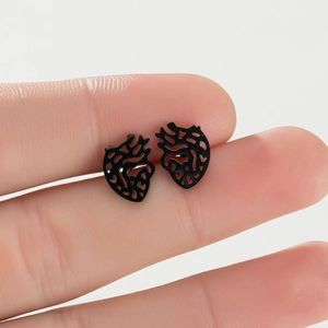 Macro shot of matte black anatomical heart stud earrings with hollow design detail