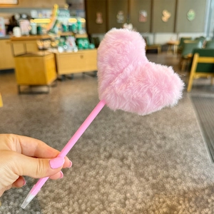 Cute pink plush heart-shaped ballpoint pen with fluffy texture in hand-held view