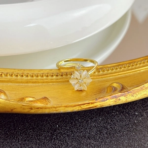 Detailed shot of a rotating cat eye flower ring on a golden tray with opal petals