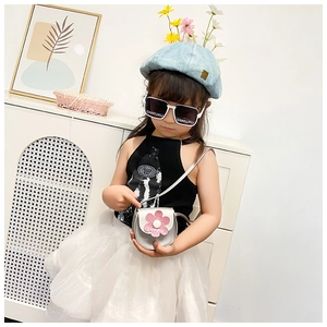 Detail of a girl wearing a silver sequin flower crossbody bag with stylish summer accessories