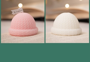 Close-up of pink and white knitted hat scented candles for Christmas decor