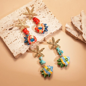 Detailed shot of starfish and colorful fish earrings with red beads and turquoise stone