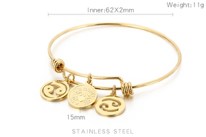 Detail of adjustable gold stainless steel bangle with Cancer zodiac charms and engraving