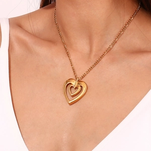 Detailed view of model wearing a double heart 18K gold plated stainless steel necklace