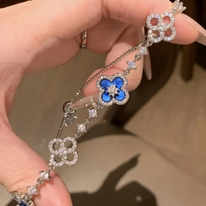 Macro shot of clover bracelet with blue enamel inlay and sparkling zircon crystals