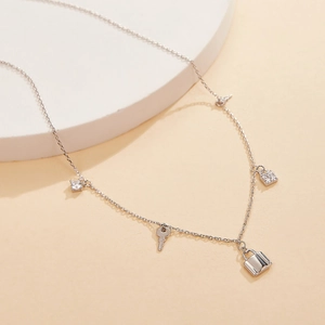 Detail of silver S925 necklace featuring zircon encrusted key and lock pendants
