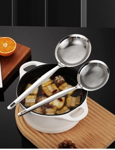 Detail showing two fine mesh stainless steel skimmers resting over a cooking pot