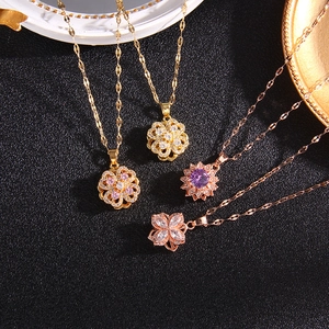 Rotating clover and floral pendant necklaces with sparkling zircons on black background