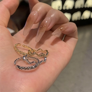 Gold and silver geometric twisted wave rings set on hand for a minimalist fashion look