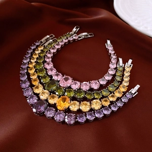 Macro shot of zircon drop bracelets in four colors on dark silk background