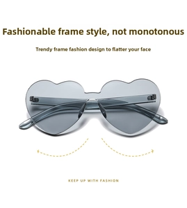 Detail view of heart-shaped rimless sunglasses with grey lenses and metal hinge screws
