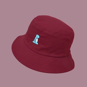 Detailed close-up of blue dinosaur embroidery on burgundy cotton fisherman bucket hat